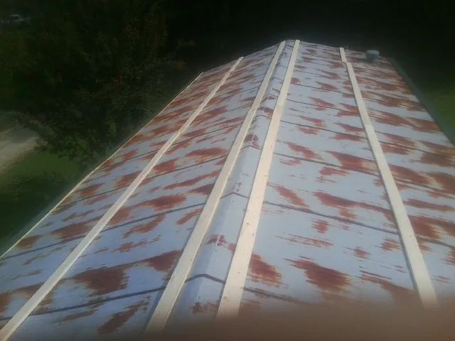 Rusted metal roof panels with new wood purlins before replacement — Storm Damage Roof Repair in Gulf Hammock by Roofing Brothers