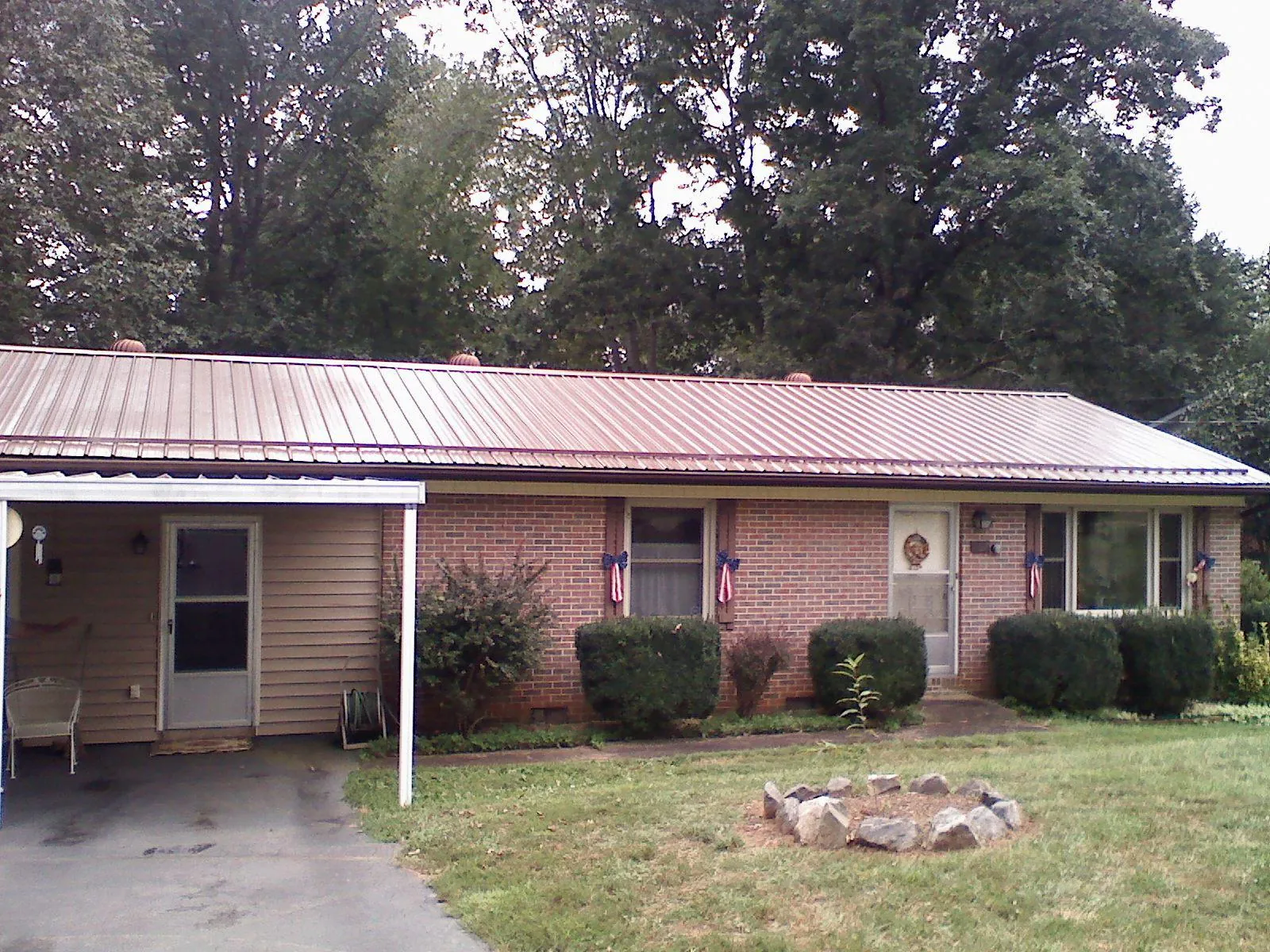 Bronze metal roof and carport on a brick ranch home — Roof Repair work by our crew in Gulf Hammock